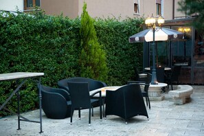 An outdoor patio area with wicker furniture, a table, and a lamp. - Il Monte (Monte San Savino)
