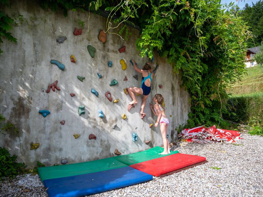 Una pared de escalada con múltiples puntos de agarre y una persona escalando.