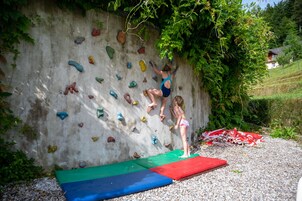 Una pared de escalada con múltiples puntos de agarre y una persona escalando.