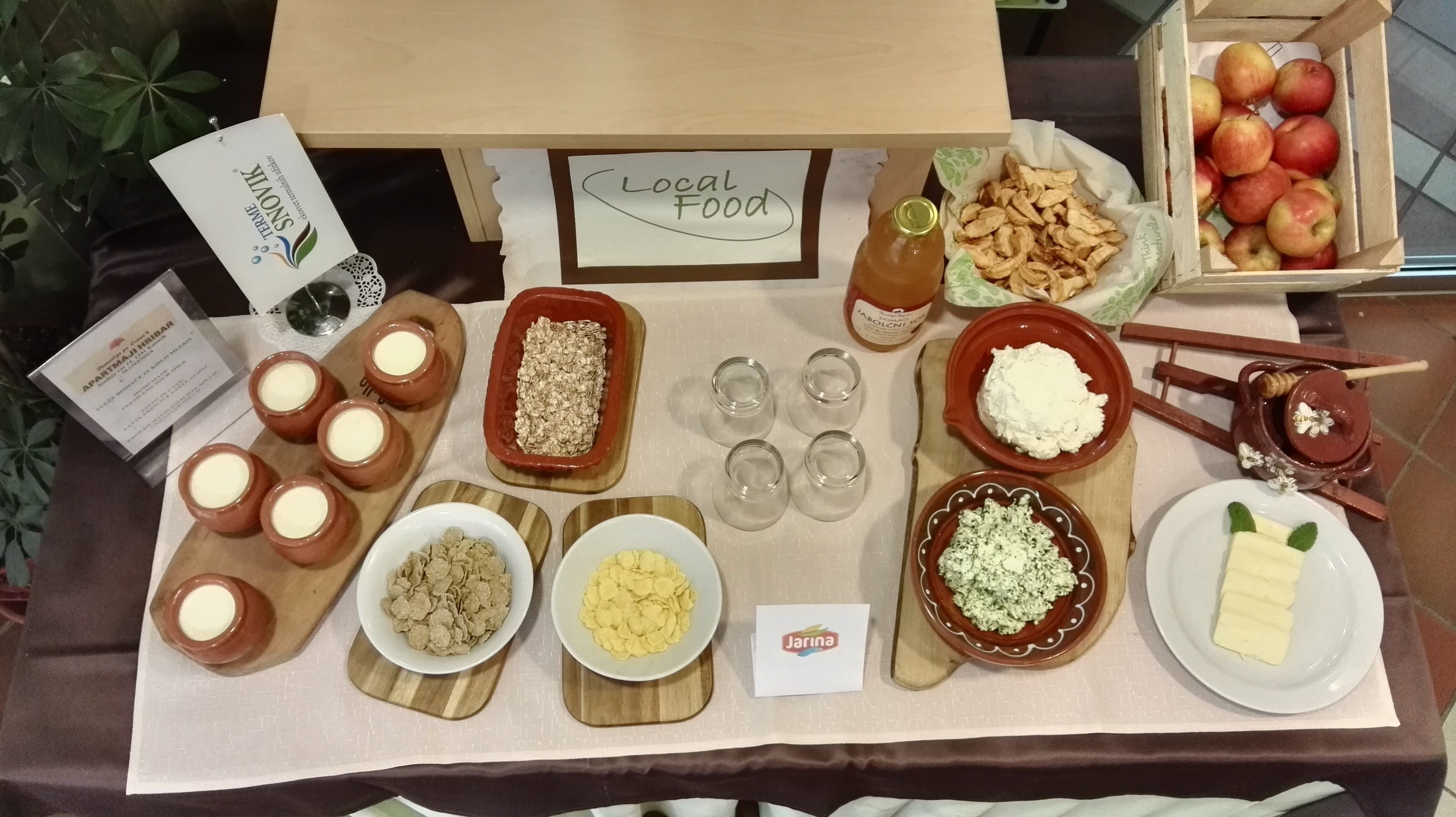 Taula d'exhibició de menjar amb diversos plats i ingredients etiquetats com 'Local Food'.