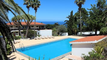 Een buitenzwembad en ligstoelen