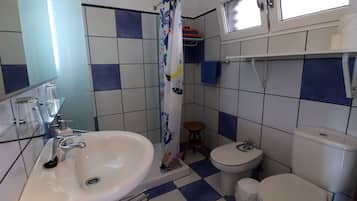 Een badkamer met een wit wastafel, toilet en douchegordijn.