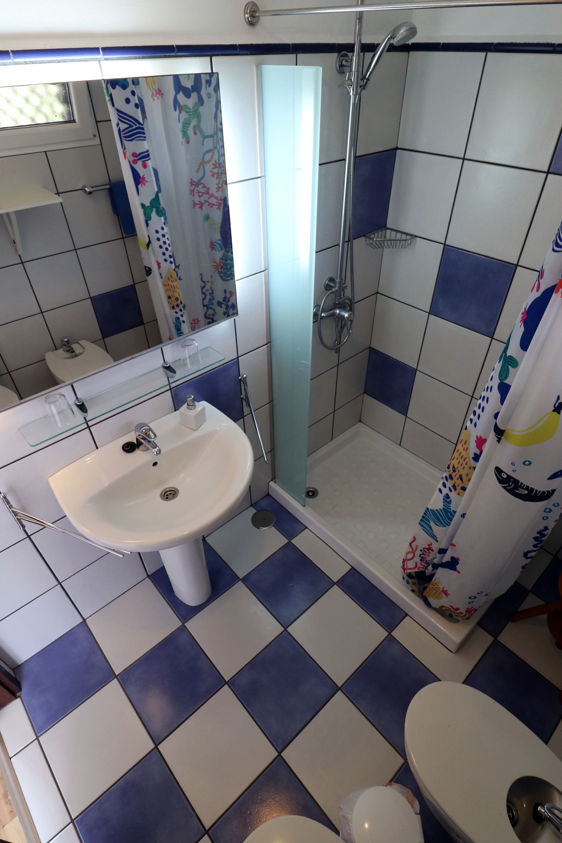 A bathroom with a sink, toilet, and shower.