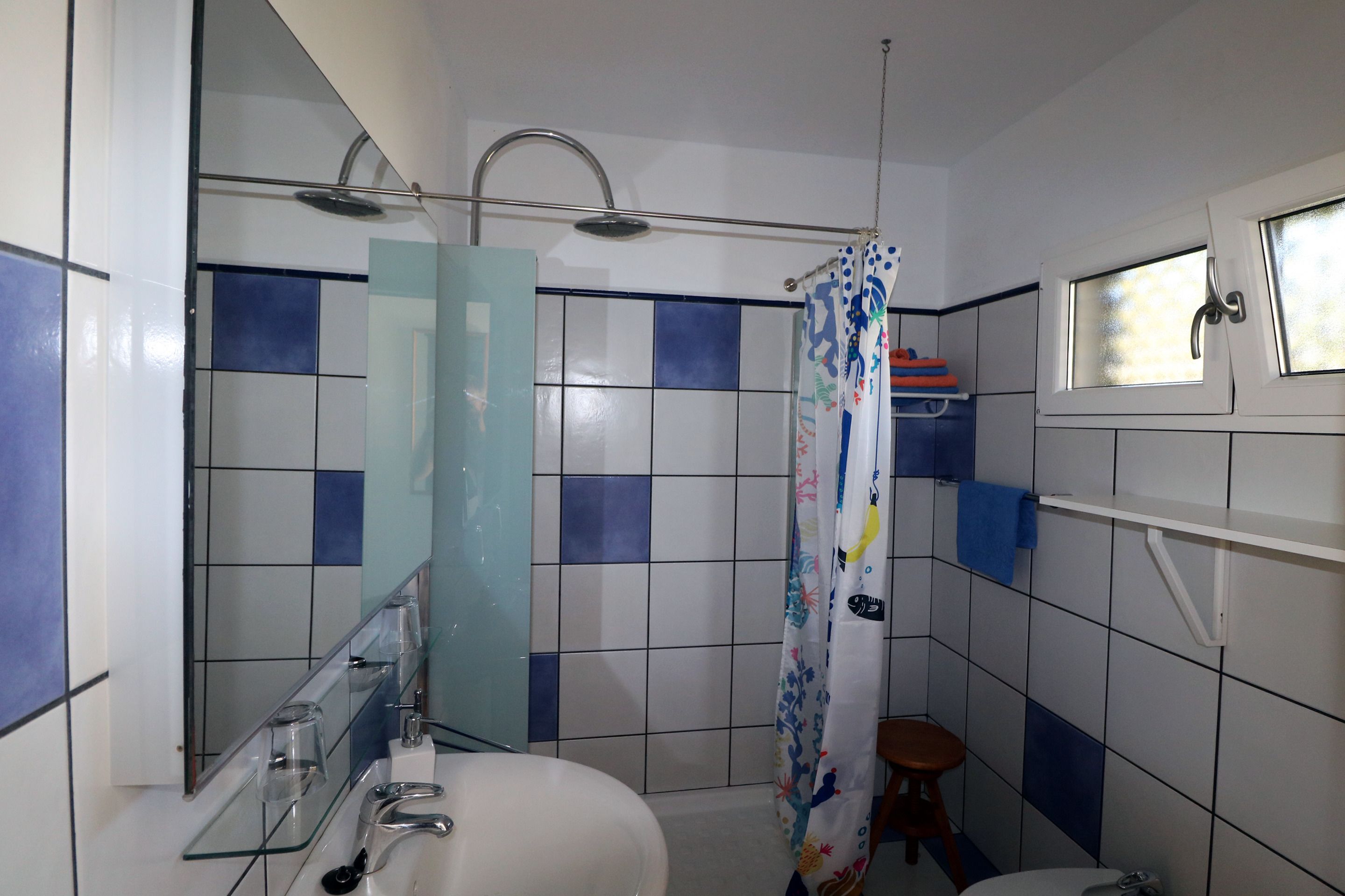 Een badkamer met een douche, toilet en wastafel.