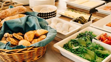 Ein Buffet mit verschiedenen Speisen, darunter Brot, Eier, Gemüse und Käse.