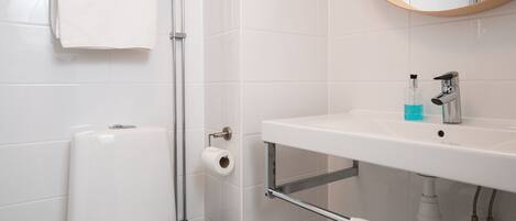 Un baño con inodoro, lavabo y espejo.