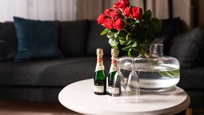A table with three champagne bottles and a vase of red roses.