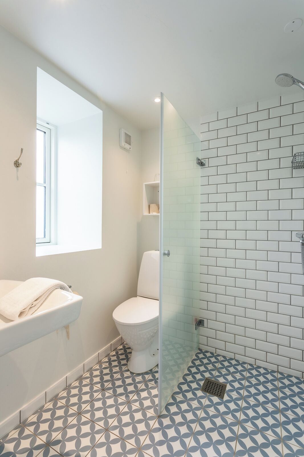 A bathroom with a toilet, sink, and shower area.