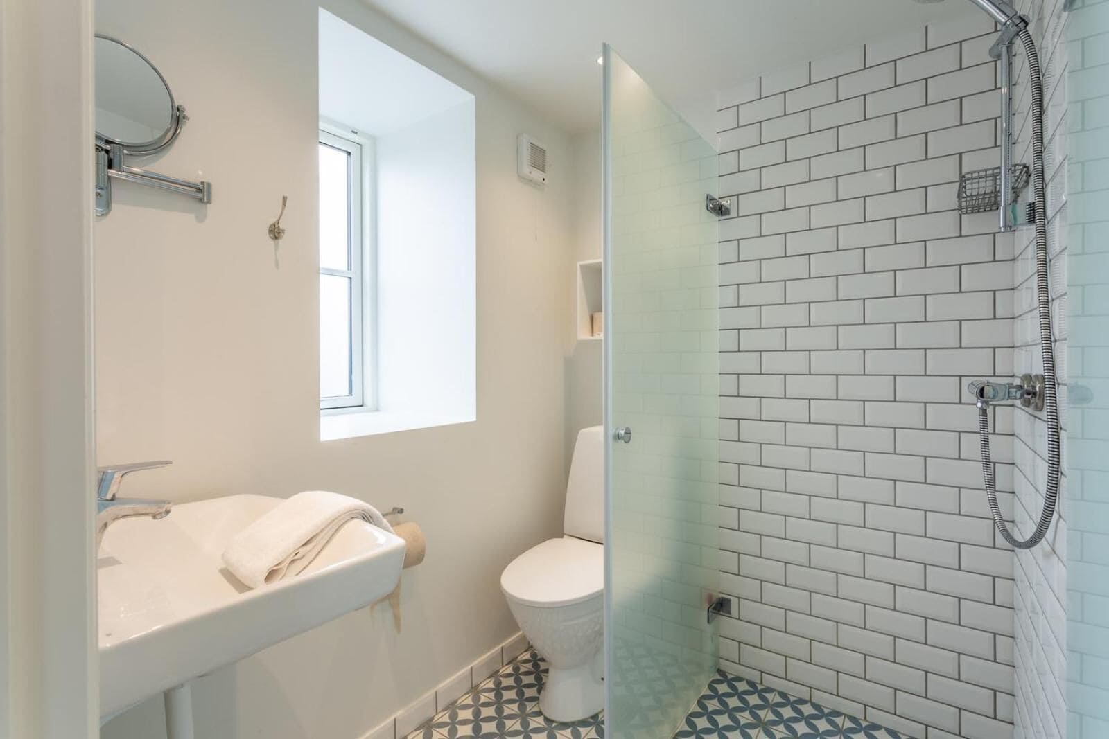 A bathroom with a white sink, toilet, and shower.