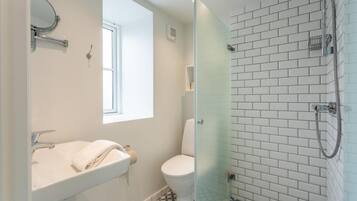 A bathroom with a white sink, toilet, and shower.