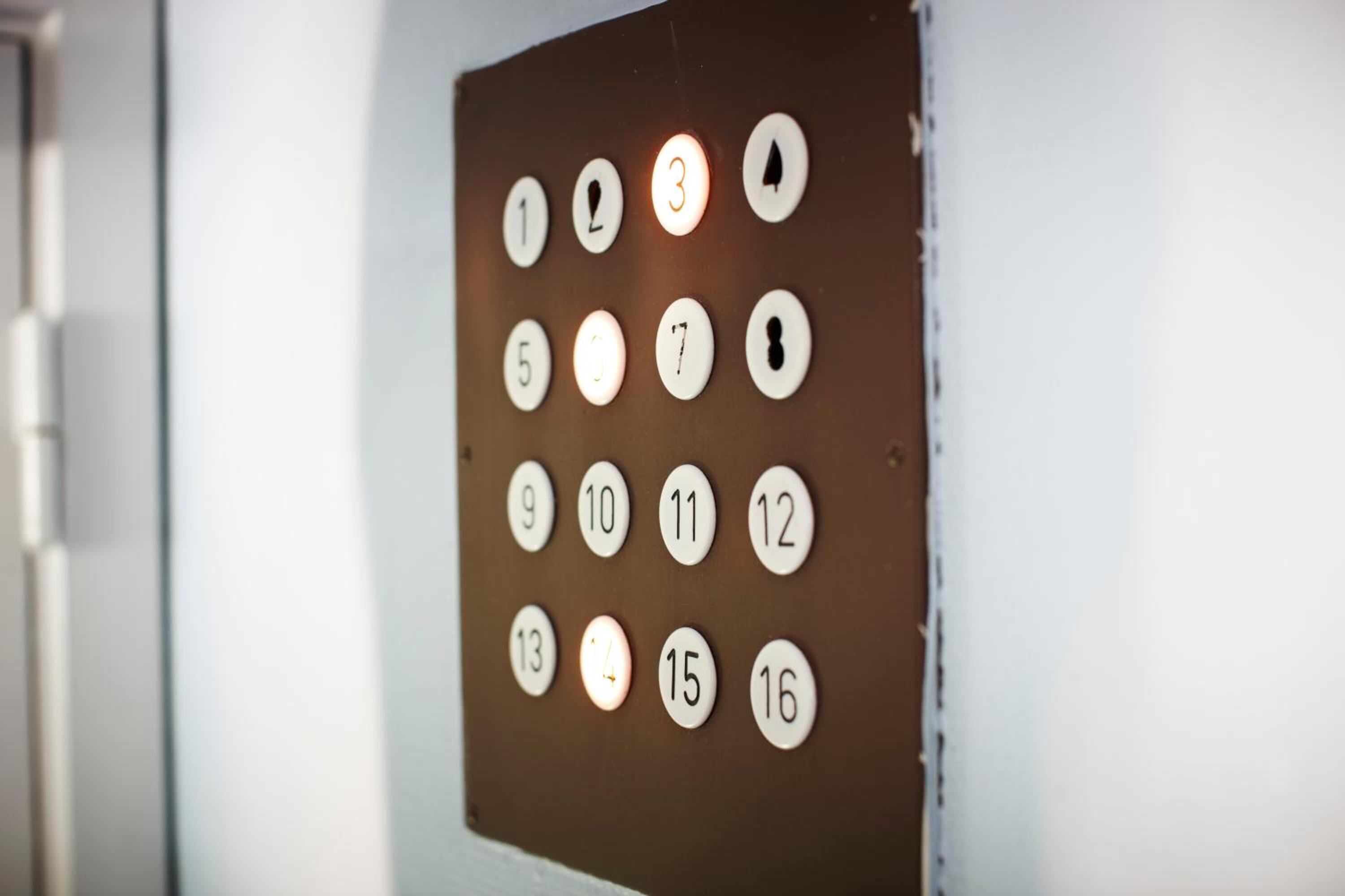 A wall with numbered buttons, likely for an elevator.