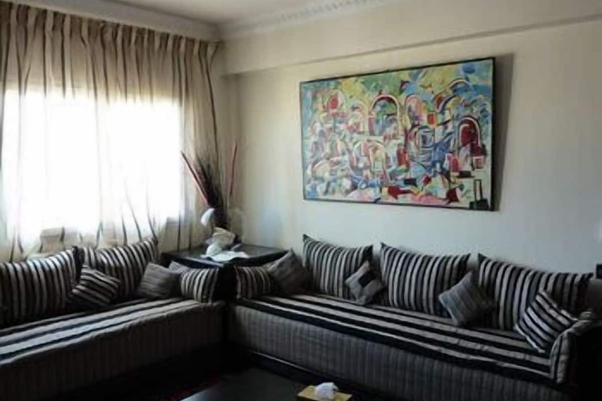A living room with a striped sofa set, a coffee table, and a painting on the wall.