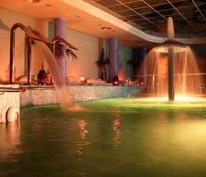 Un espace de bien-être doté d’un élément aquatique, de sièges en pierre et d’un éclairage d’ambiance.