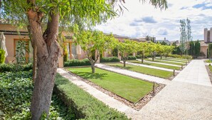 A well-maintained garden with neatly trimmed hedges and a variety of trees.