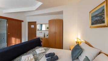 A hotel room with a bed, a desk, a wardrobe, and a bathroom.