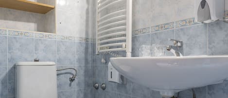 A bathroom with a toilet, sink, and mirror.