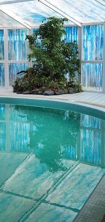 Una piscina techada, sillones reclinables de piscina