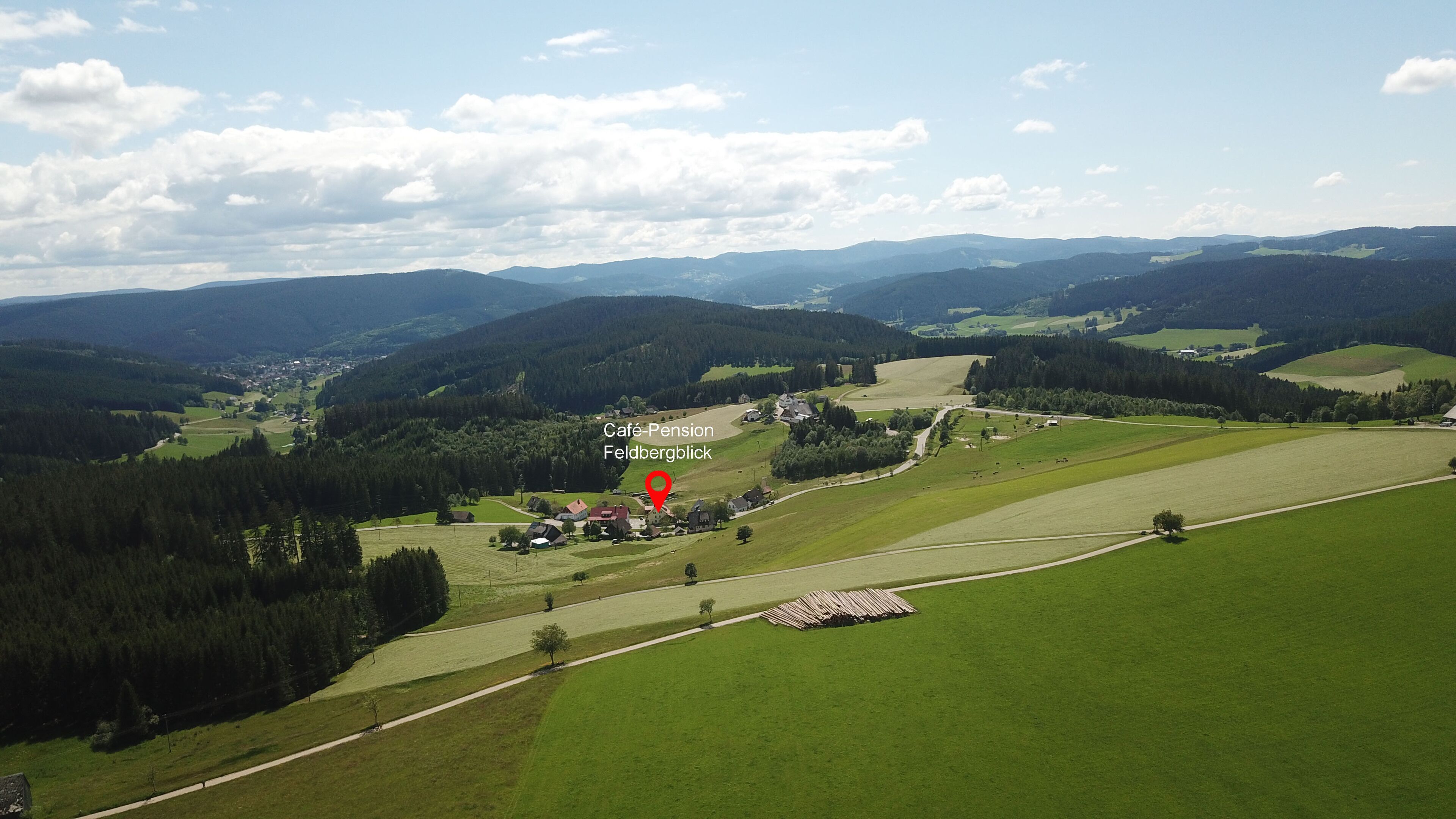 Vista aérea de uma paisagem rural com um local indicado para o Café-Pension Feldbergblick.