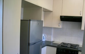 A kitchen with a stainless steel refrigerator, a kettle, and a stove. - Mouille Grange 203 - Apartment (Cape Town)