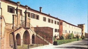 A building with a long facade, multiple windows, and a central staircase leading to an upper level. - Ristorante Locanda Milano (Gambolo)
