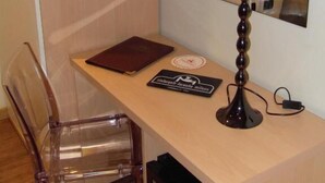 A small workspace with a desk, a chair, a lamp, and a mirror. - Ristorante Locanda Milano (Gambolo)