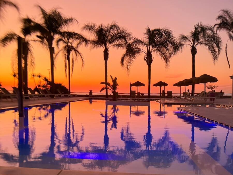 Una piscina al aire libre de temporada, sombrillas, tumbonas
