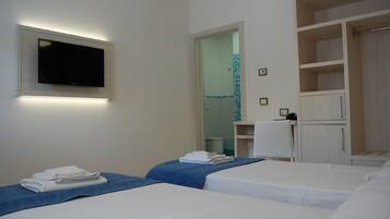 A hotel room with two beds, a TV mounted on the wall, and a wardrobe with open shelves.