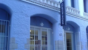 Ein Gebäude mit blauer Fassade, weißen Fensterrahmen und einem Schild mit der Aufschrift 'GLASTON HOUSE'.