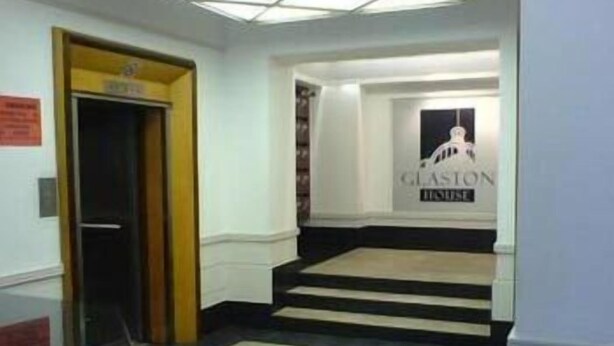 Ein Hotel Eingang mit einem Schild, auf dem 'Glaston House' steht.