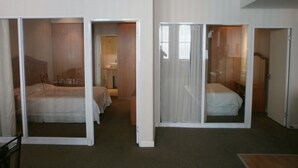 Ein Hotelzimmer mit zwei Betten, einem Badezimmer und einem Schrank.