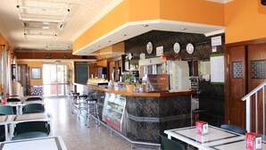 A restaurant interior with a counter, bar area, and seating arrangement. - El Faisan C&R Hotel (Arcos de la Frontera)