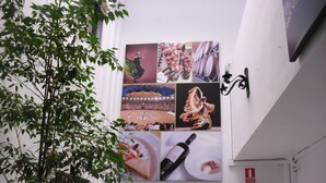 A wall with a series of framed pictures depicting various events and a wine bottle. - El Faisan C&R Hotel (Arcos de la Frontera)