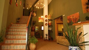 A staircase with patterned tiles, a chandelier, and various potted plants. - Hotel Apartamento Rural Finca La Media Legua (Los Marines)