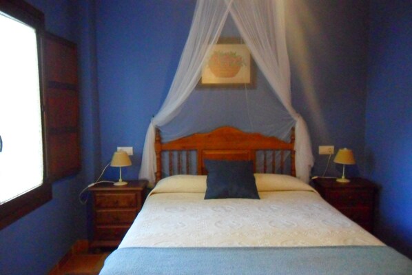 A bedroom with a bed, two bedside tables, and a window. - Hotel Apartamento Rural Finca La Media Legua (Los Marines)
