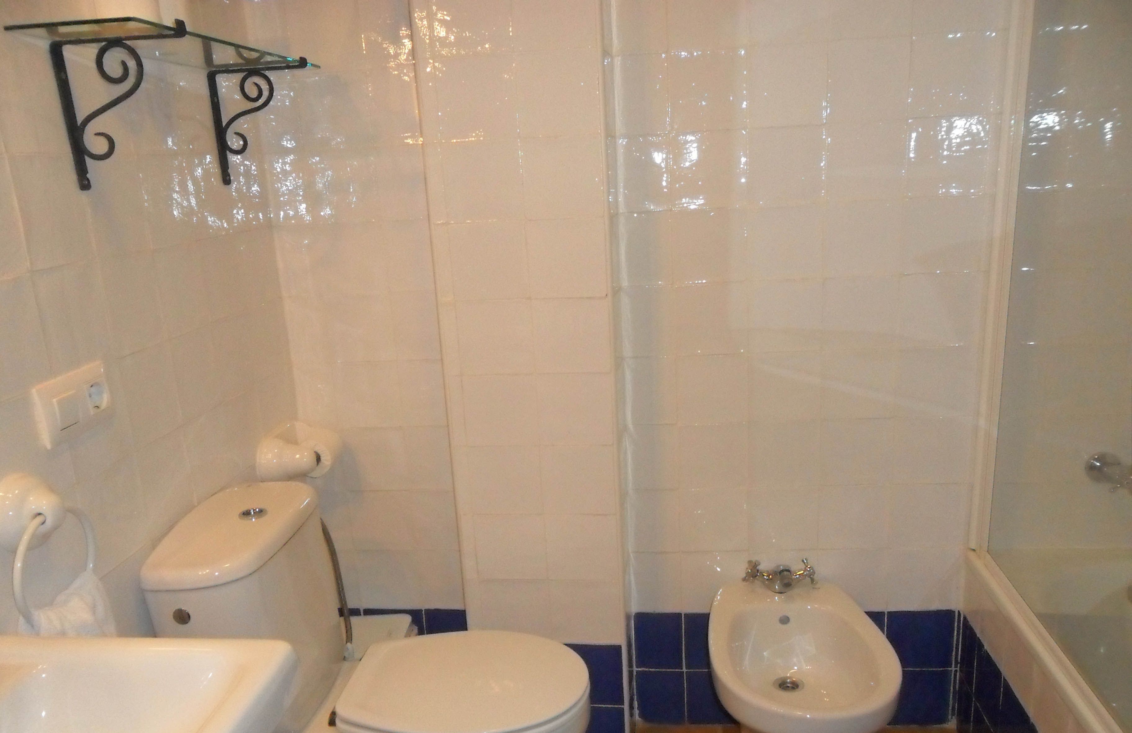 Un baño con inodoro, bidé y lavamanos.