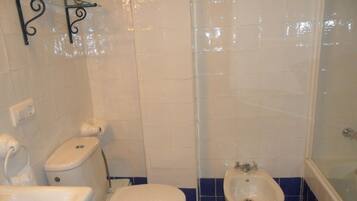 Un baño con inodoro, bidé y lavamanos.