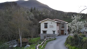 A two-story building with a stone facade and a red roof, named 'Alesga'.