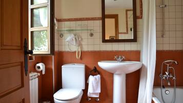 A bathroom with a toilet, sink, and shower.