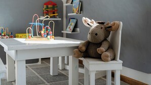 A room with a white table, a stuffed donkey, and a toy structure. - Klostergasthof Roggenburg (Roggenburg)