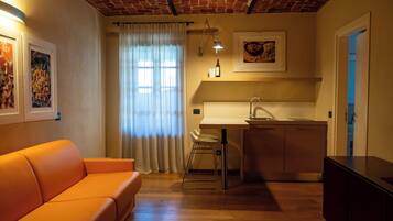 A compact living space with a kitchen, a sofa, and a dining area.