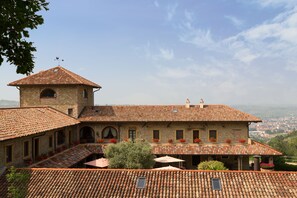 A historic building with a tiled roof, multiple windows, and a central tower. - I Tre Poggi Dimora di Charme (Canelli)