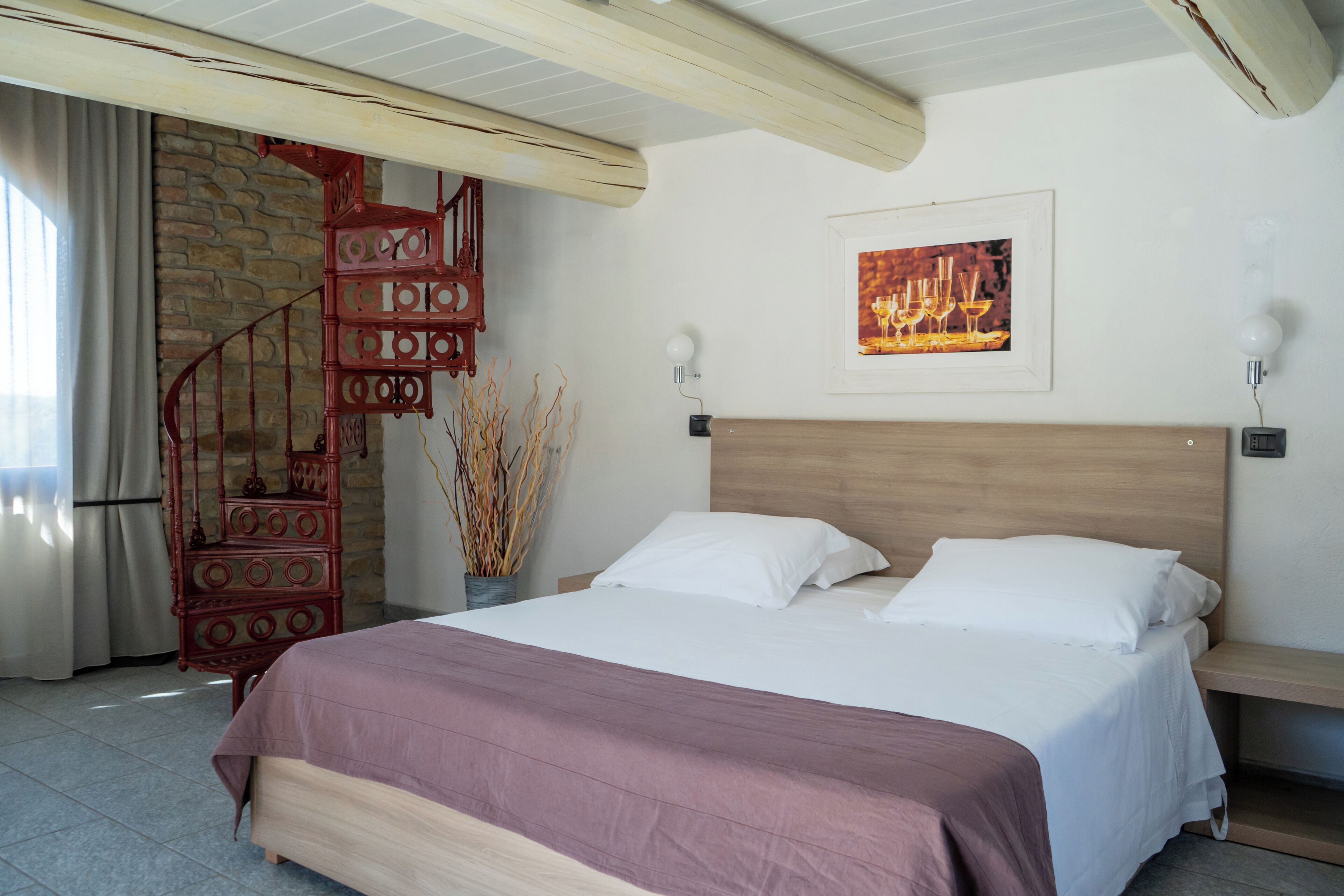 Ein Schlafzimmer mit einem hölzernen Kopfteil, einem Bett mit weißer Bettwäsche, einer roten Ziertreppe und einem gerahmten Bild an der Wand.