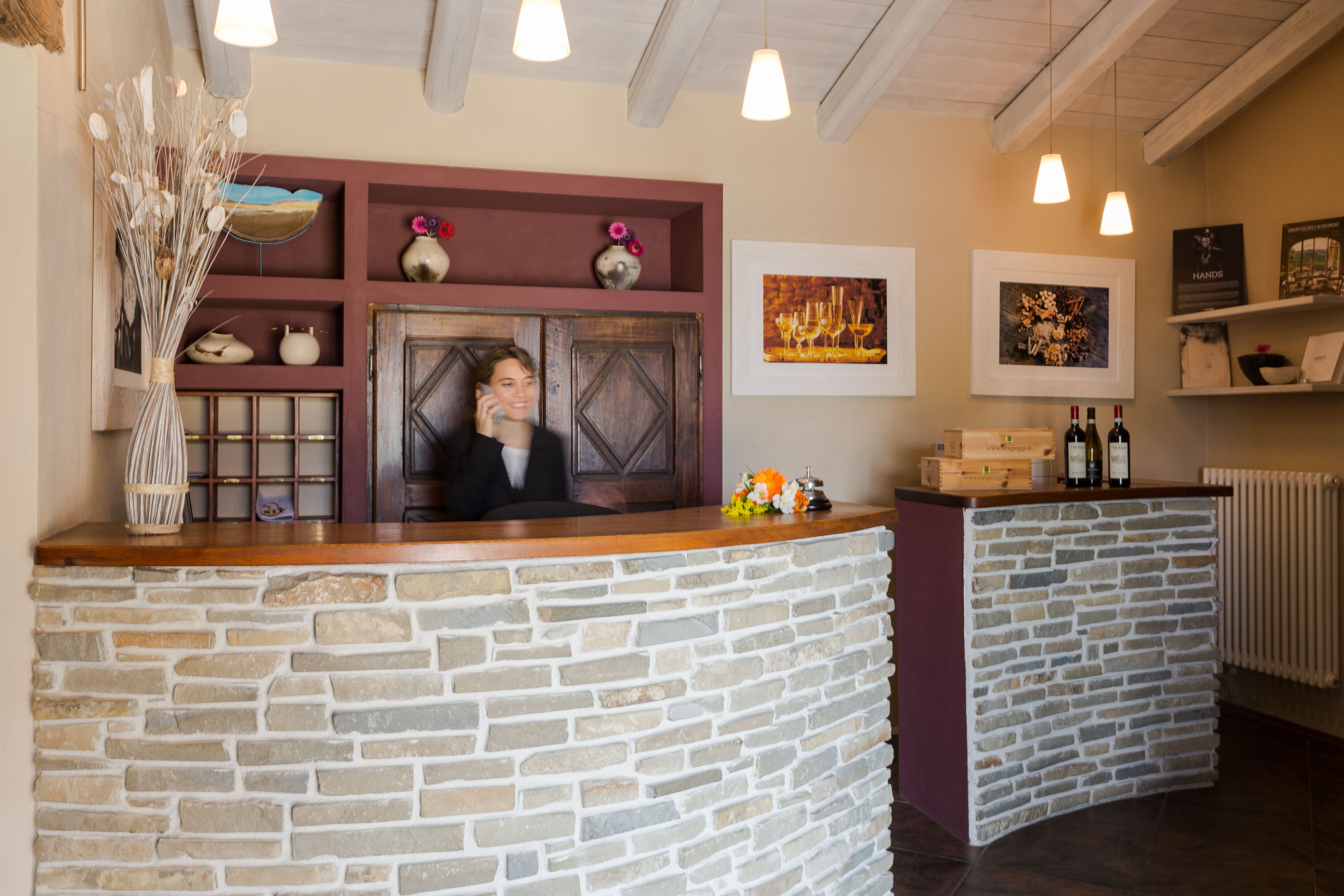 Un espace d’accueil avec un comptoir en pierre, une porte en bois et divers objets décoratifs.