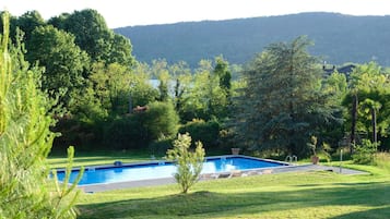 Una piscina al aire libre, sillones reclinables de piscina