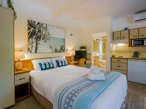 Relax in this stylish room featuring a large bed, desk, and separate bathroom with shower, sink, and toilet.