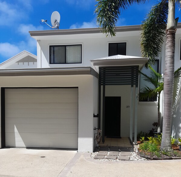 Stylish two-story home with a clean design, featuring a garage and a covered entryway.