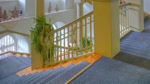 A multi-level interior with a staircase, columns, and a railing. - Badhotel Bad Brückenau (Bad Brueckenau)