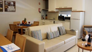 A compact living space with a sofa, dining table, and kitchenette.