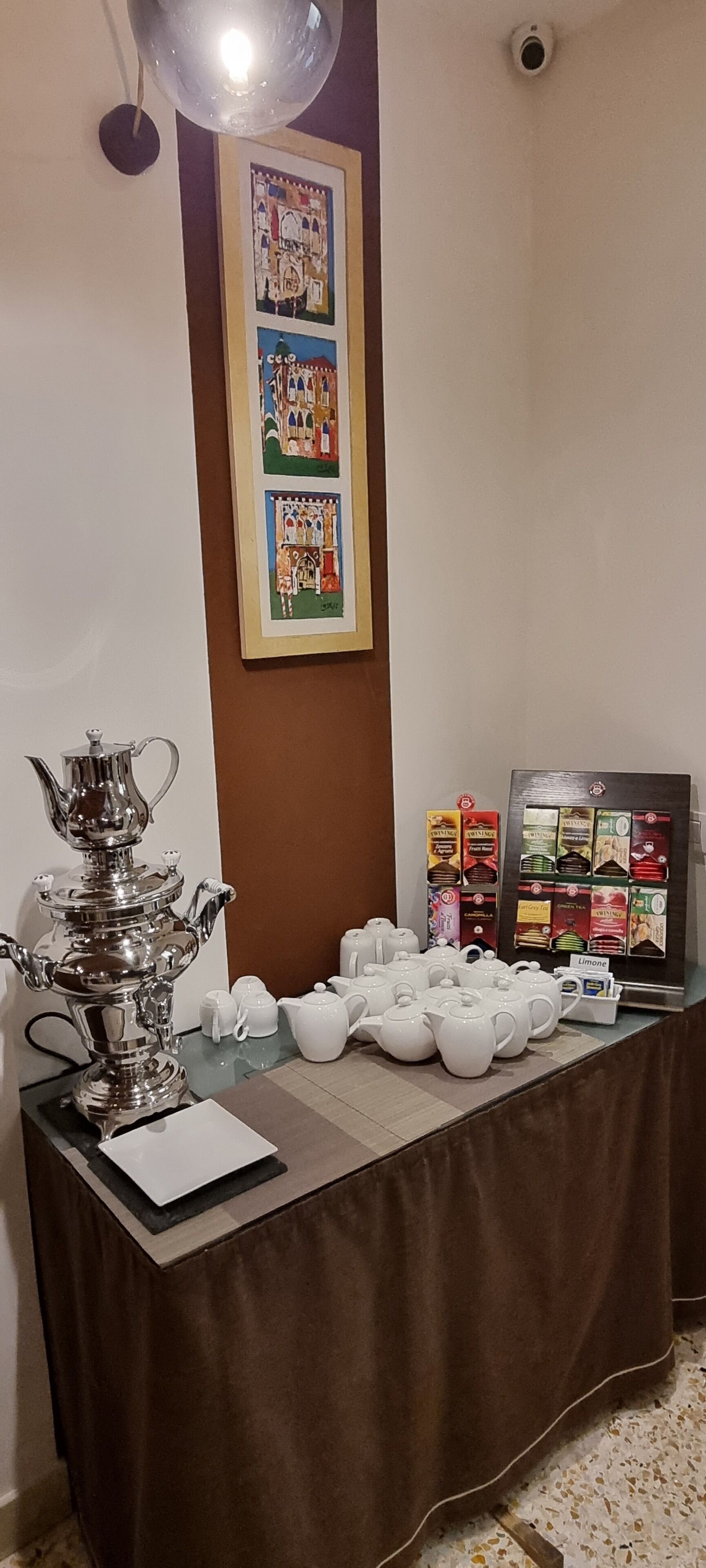 A table with a samovar, teapots, and a display of tea boxes.