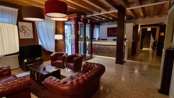 A modern living room with leather sofas, a coffee table, and a TV.